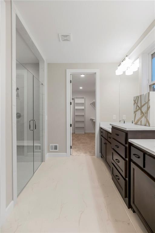 16388 S Brougham Dr, Olathe, KS 66062 - bathroom with a spacious closet, a shower stall, marble finish floor, and vanity