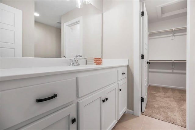 16388 S Brougham Dr, Olathe, KS 66062 - bathroom featuring a walk in closet, baseboards, vanity, and tile patterned flooring