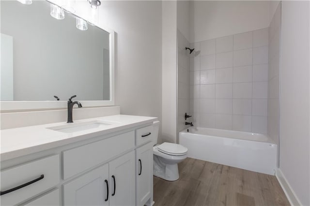 full bathroom with toilet, vanity, tiled shower / bath, and hardwood / wood-style flooring