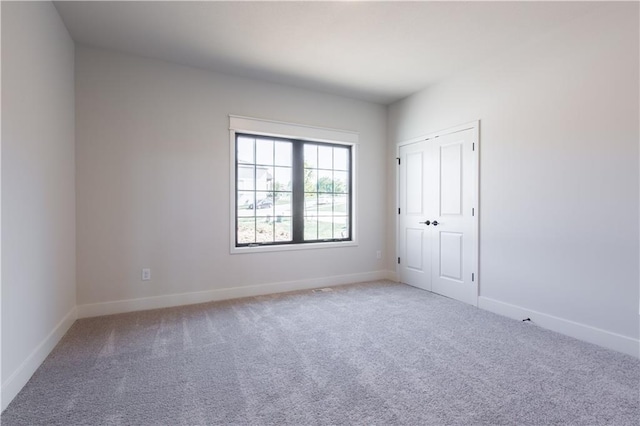 spare room featuring light carpet