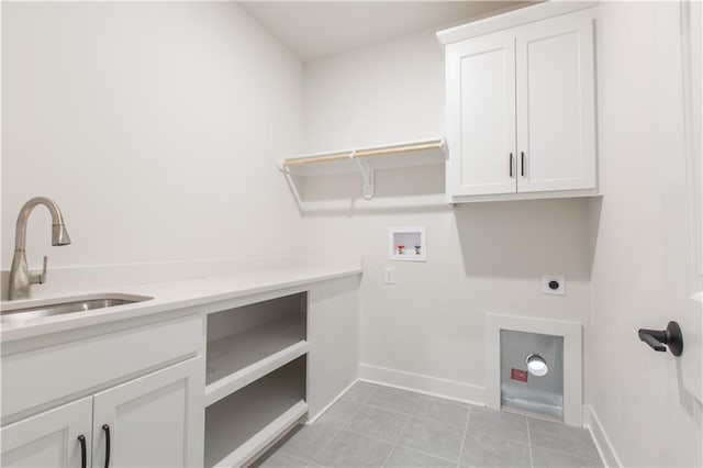 clothes washing area featuring sink, hookup for a washing machine, hookup for an electric dryer, cabinets, and light tile flooring