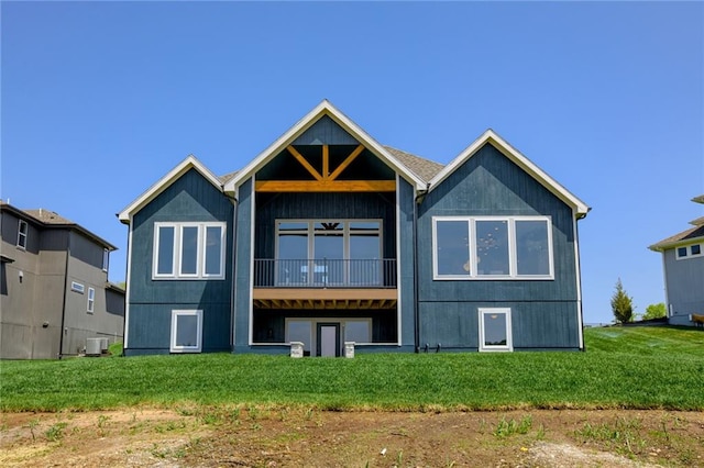 rear view of property featuring a yard, a balcony, and central AC unit