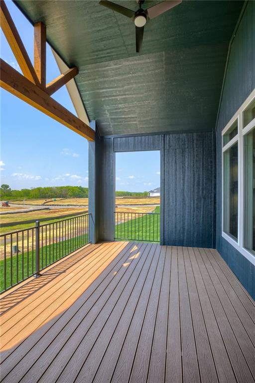 wooden terrace featuring ceiling fan and a yard