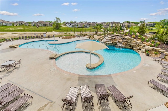 view of pool with a yard, pool water feature, a jacuzzi, and a patio