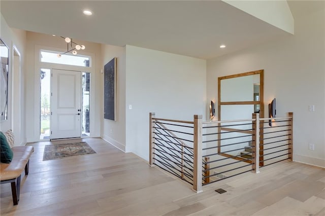 entryway with light hardwood / wood-style flooring and an inviting chandelier