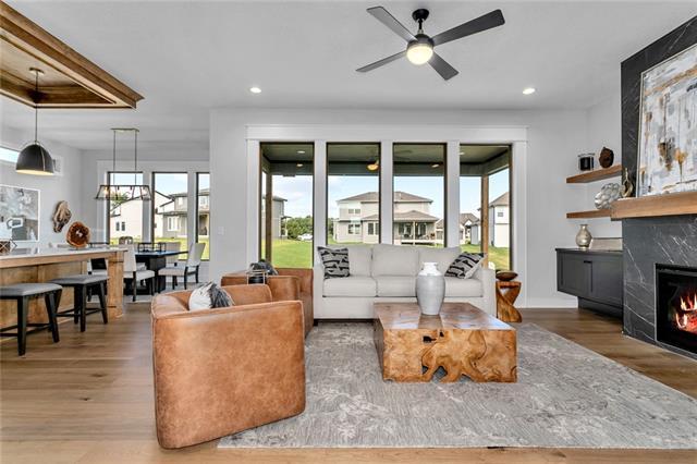 living room featuring a large fireplace, ceiling fan, and dark hardwood / wood-style flooring