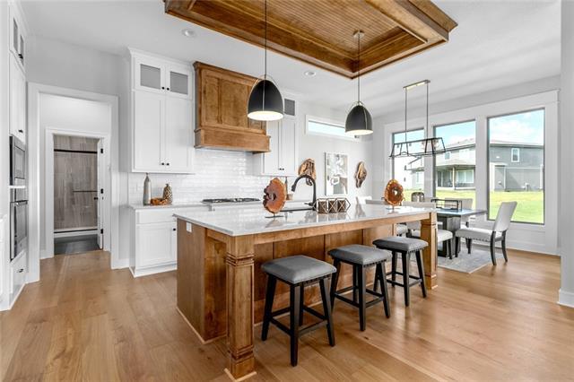 kitchen featuring white cabinets, light hardwood / wood-style floors, and decorative light fixtures