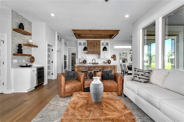 living room featuring wine cooler, dark wood-type flooring, and sink