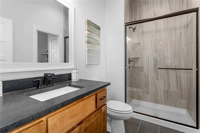 bathroom featuring an enclosed shower, vanity, tile flooring, and toilet