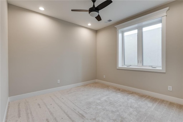 unfurnished room featuring light colored carpet, ceiling fan, and plenty of natural light