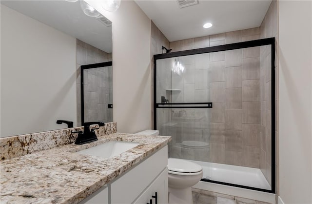 bathroom with tile flooring, toilet, large vanity, and walk in shower