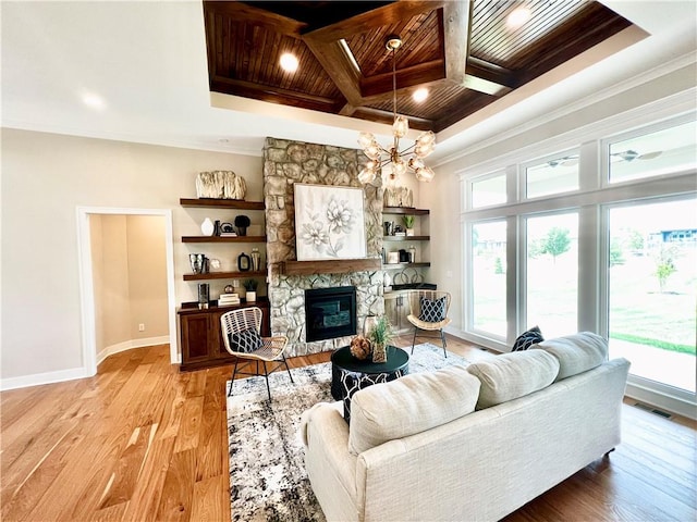 living room featuring light hardwood / wood-style floors, crown molding, a notable chandelier, a fireplace, and wood ceiling