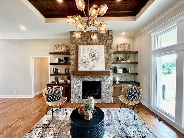 living area with a chandelier, a fireplace, wooden ceiling, a tray ceiling, and light wood-type flooring