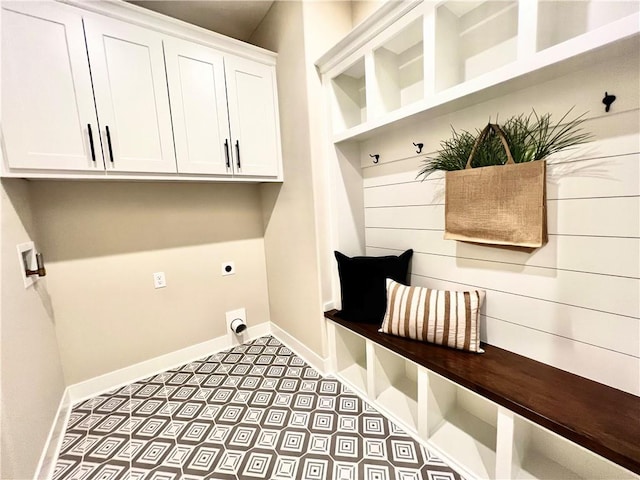 clothes washing area with hookup for an electric dryer, cabinets, and tile floors