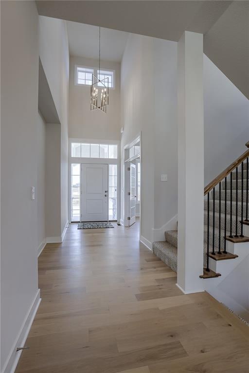 entrance foyer with a chandelier, a high ceiling, and light hardwood / wood-style floors