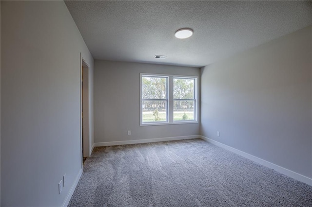 empty room with carpet and a textured ceiling