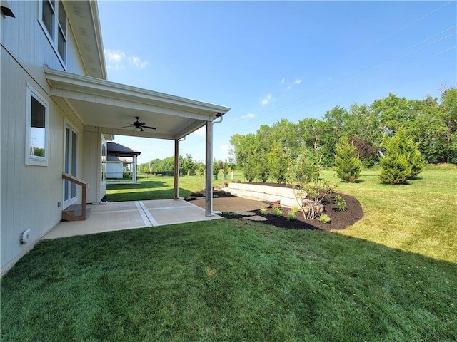 view of yard with ceiling fan and a patio area