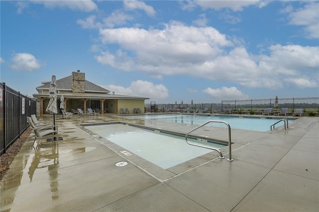 view of pool featuring a patio area and a water view