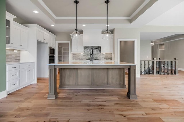 23217 W 124th Pl, Olathe, KS 66061 - kitchen featuring a tray ceiling, stainless steel appliances, light countertops, white cabinets, and decorative backsplash