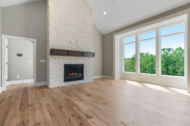 23217 W 124th Pl, Olathe, KS 66061 - unfurnished living room with high vaulted ceiling, light wood finished floors, and a stone fireplace