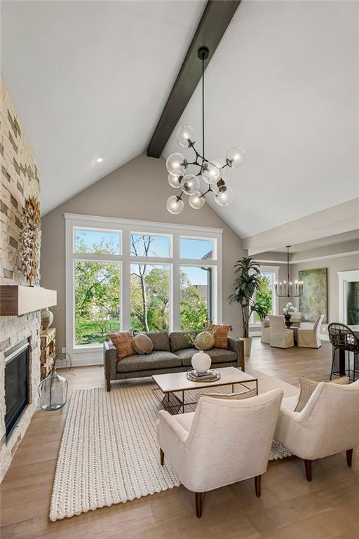 living area with a notable chandelier, high vaulted ceiling, plenty of natural light, and beam ceiling