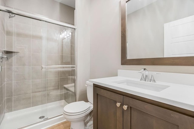 full bath featuring vanity, toilet, and a shower stall