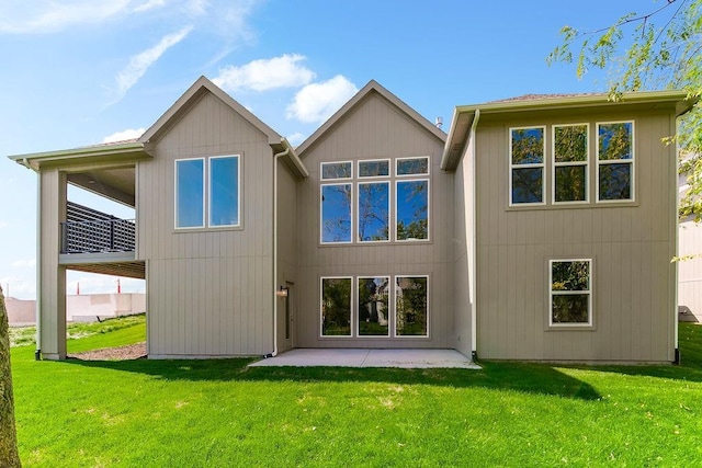 back of property with a yard and a patio area