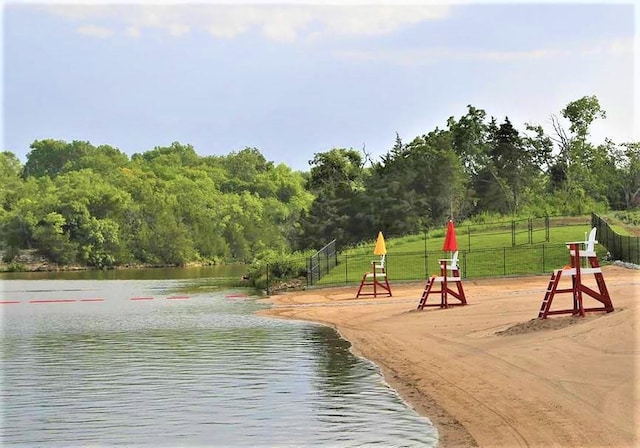 exterior space with a water view and fence