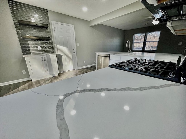 kitchen featuring ceiling fan, white cabinetry, light stone countertops, and dark wood-type flooring