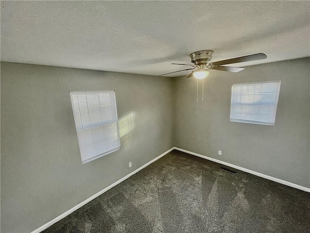 carpeted empty room with ceiling fan and a textured ceiling