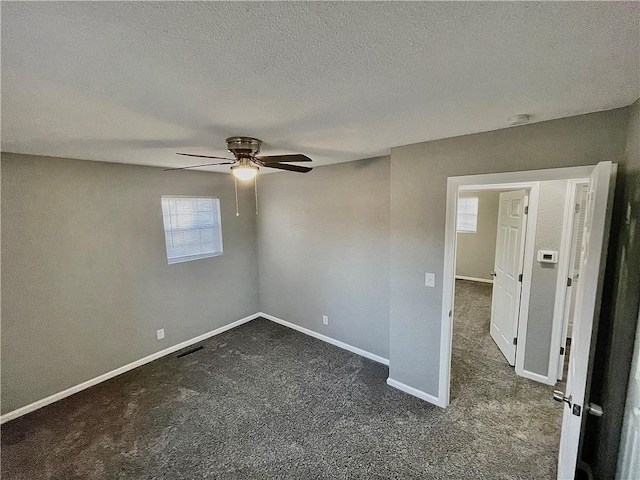 carpeted spare room with ceiling fan and a textured ceiling