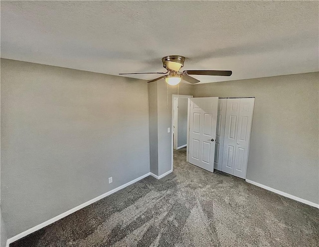 unfurnished bedroom featuring a textured ceiling, a closet, ceiling fan, and dark carpet