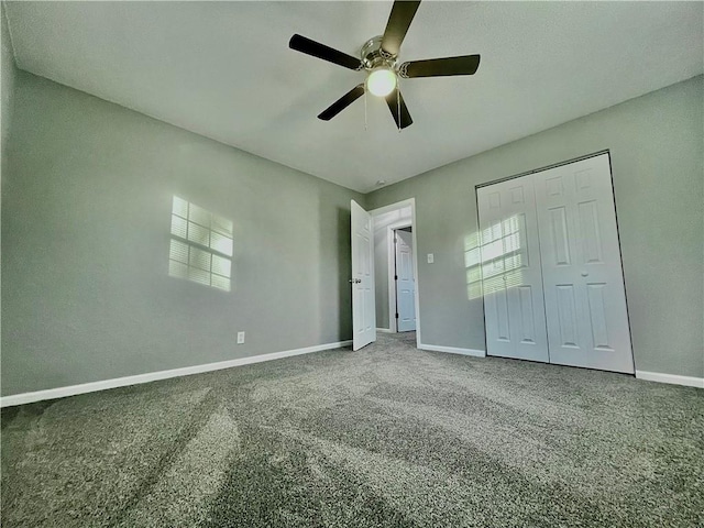 unfurnished bedroom featuring a closet, dark colored carpet, and ceiling fan