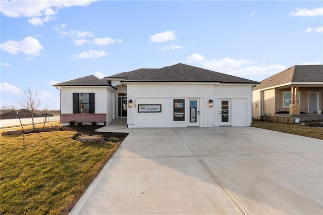 prairie-style house featuring a garage and a front lawn