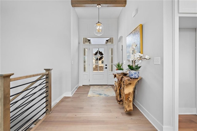 entryway featuring beamed ceiling and light hardwood / wood-style floors