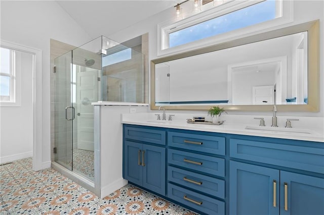 bathroom with vanity with extensive cabinet space, double sink, a healthy amount of sunlight, and walk in shower