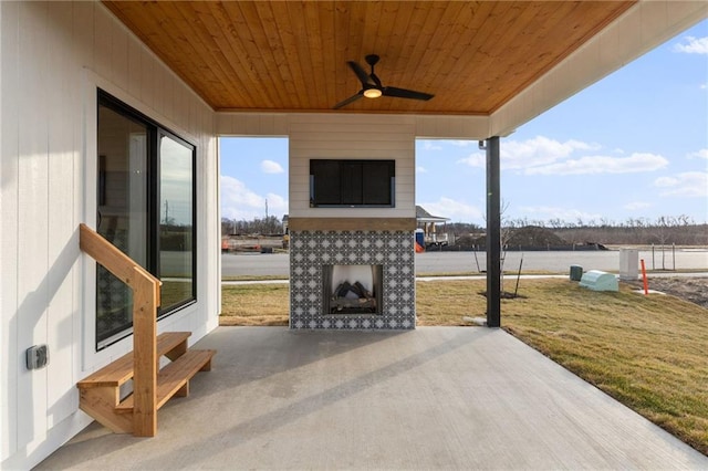 view of patio / terrace with an outdoor fireplace and ceiling fan