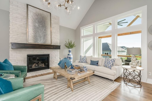 living room with brick wall, a healthy amount of sunlight, a brick fireplace, and light hardwood / wood-style flooring