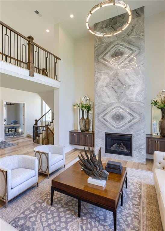 living room with a high end fireplace and light wood-type flooring