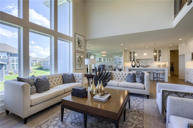 living room with plenty of natural light, a high ceiling, and hardwood / wood-style flooring