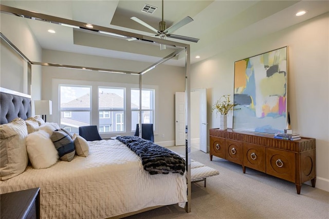 bedroom with a tray ceiling, ceiling fan, and light colored carpet