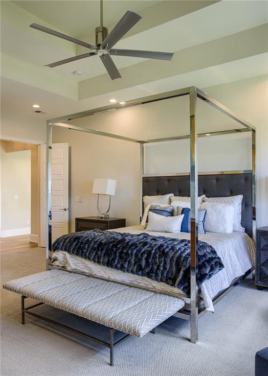 bedroom featuring ceiling fan and a raised ceiling