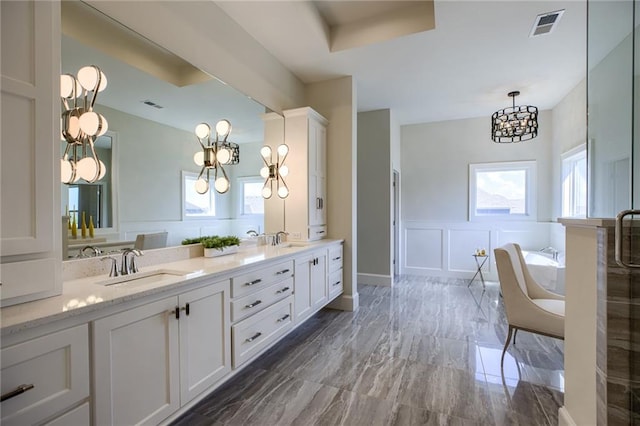 bathroom with shower with separate bathtub, a notable chandelier, double sink, and large vanity