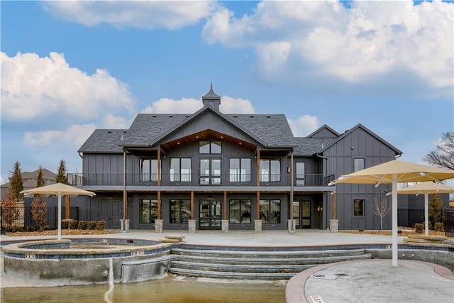 back of property with a balcony and a patio