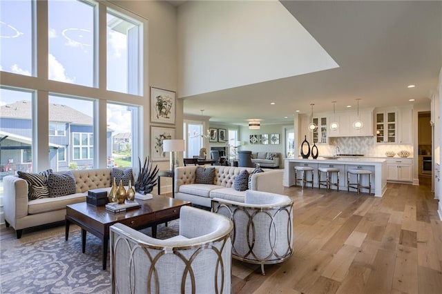 living room with light hardwood / wood-style flooring and a towering ceiling