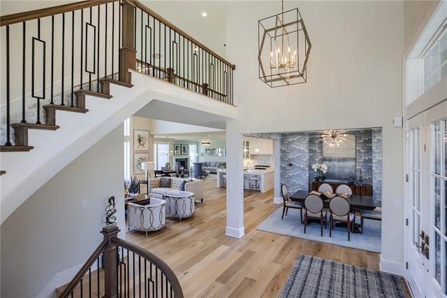 interior space featuring a high ceiling, a chandelier, and light wood-type flooring