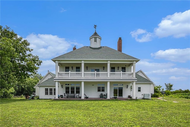 back of property featuring a lawn and a balcony