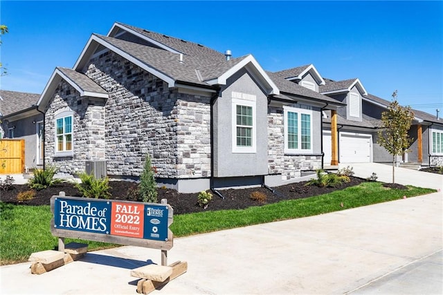 view of front facade featuring central AC unit and a garage