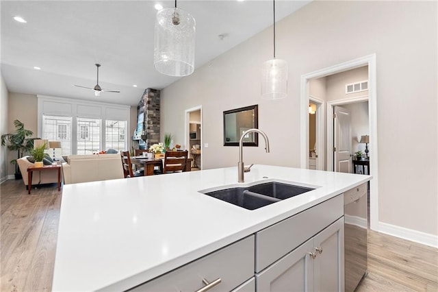 kitchen with ceiling fan, hanging light fixtures, and light wood-type flooring