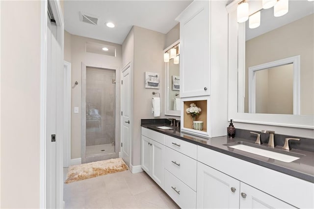 bathroom featuring tile floors, tiled shower, and double vanity